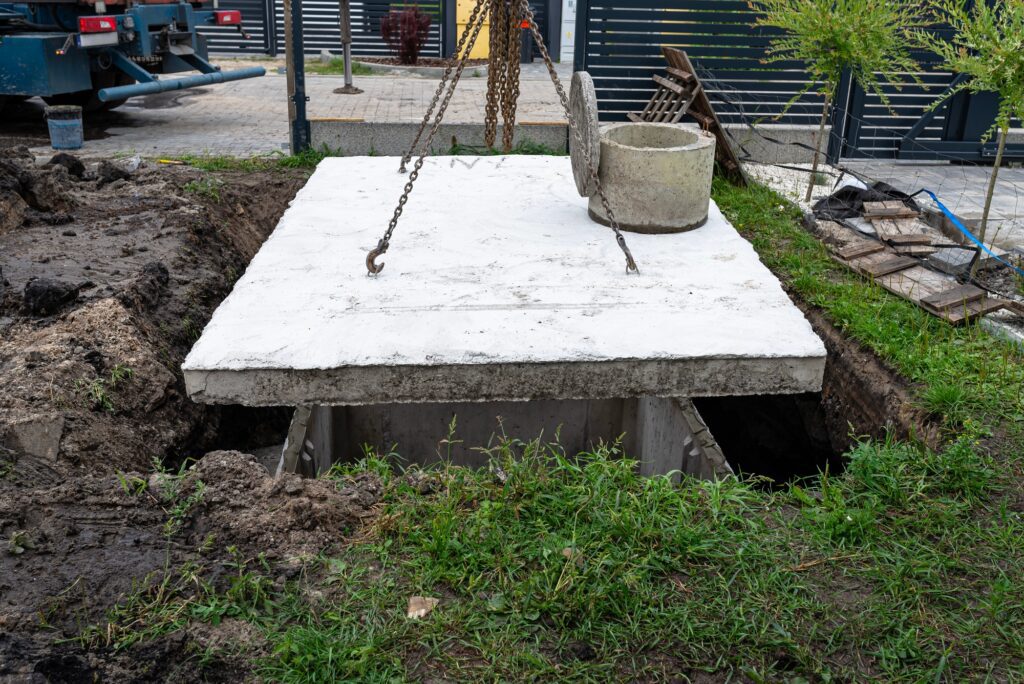 Concrete septic tank with a capacity of 10 m3 located in the garden next to the house.